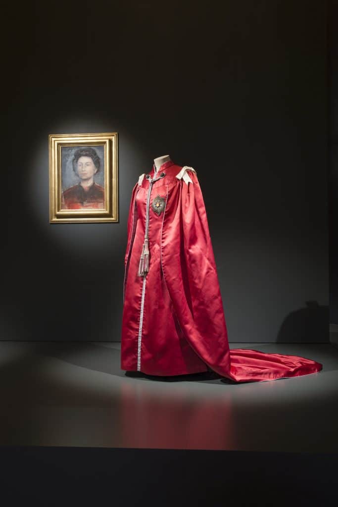 The Queen's mantle of the Order of the British Empire, made by Ede and Ravenscroft and designed by Marion Foale,1952 Images for use only in connection with the exhibition Fashioning a Reign: 90 Years of Style from The Queen's Wardrobe at the Summer Opening of Buckingham Palace, 23 July √Ç¬≠ 2 October 2016. Images must not be archived or sold-on. Royal Collection Trust / √Ç¬© Her Majesty Queen Elizabeth II 2016. Single use only; not to be archived or passed on to third parties.